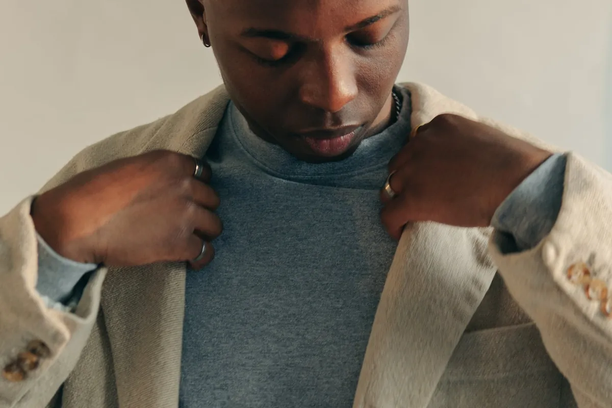 Man adjusting the lapels of a tan coat